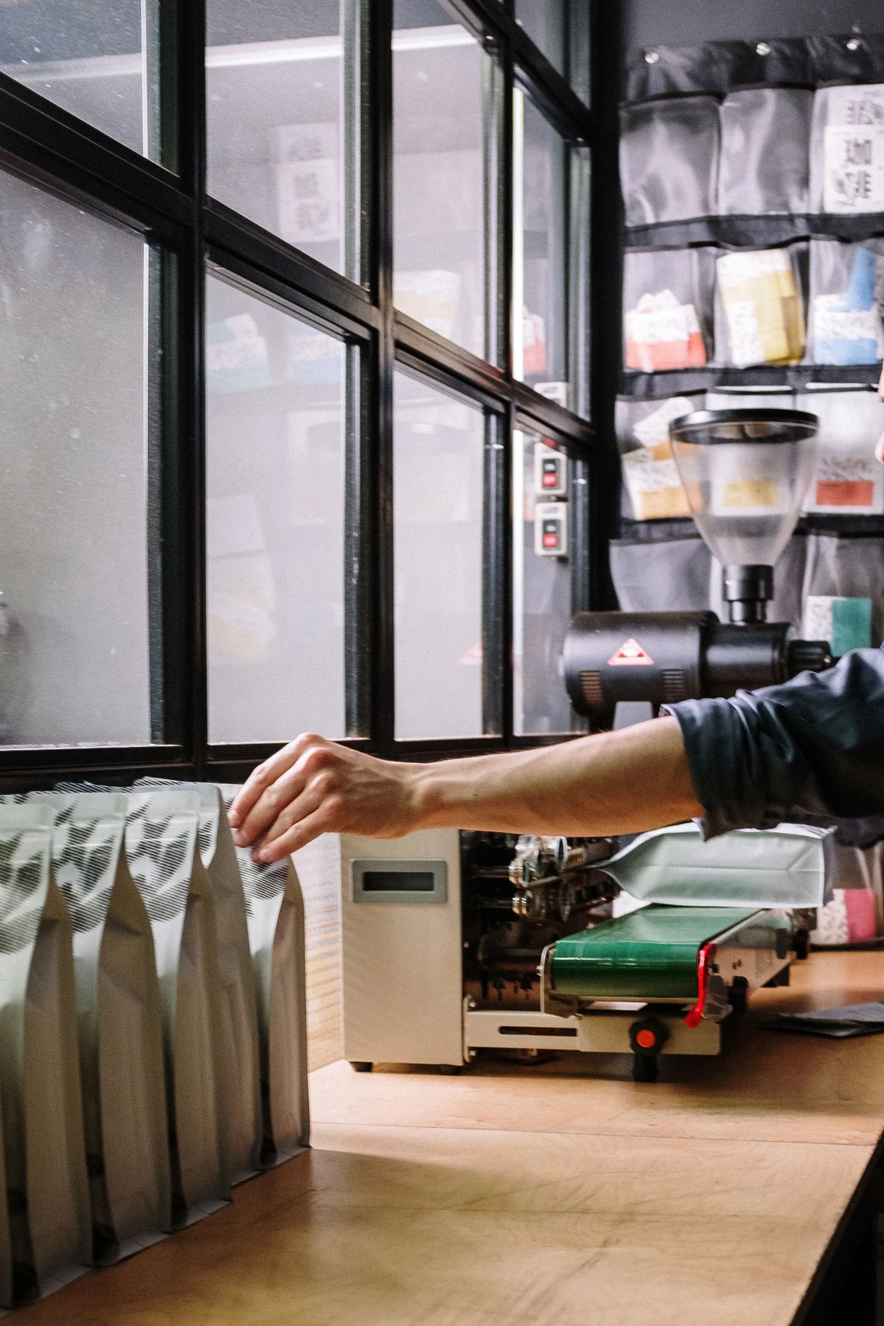 Người thợ đang đóng gói túi cà phê trong xưởng — ảnh Pexels.