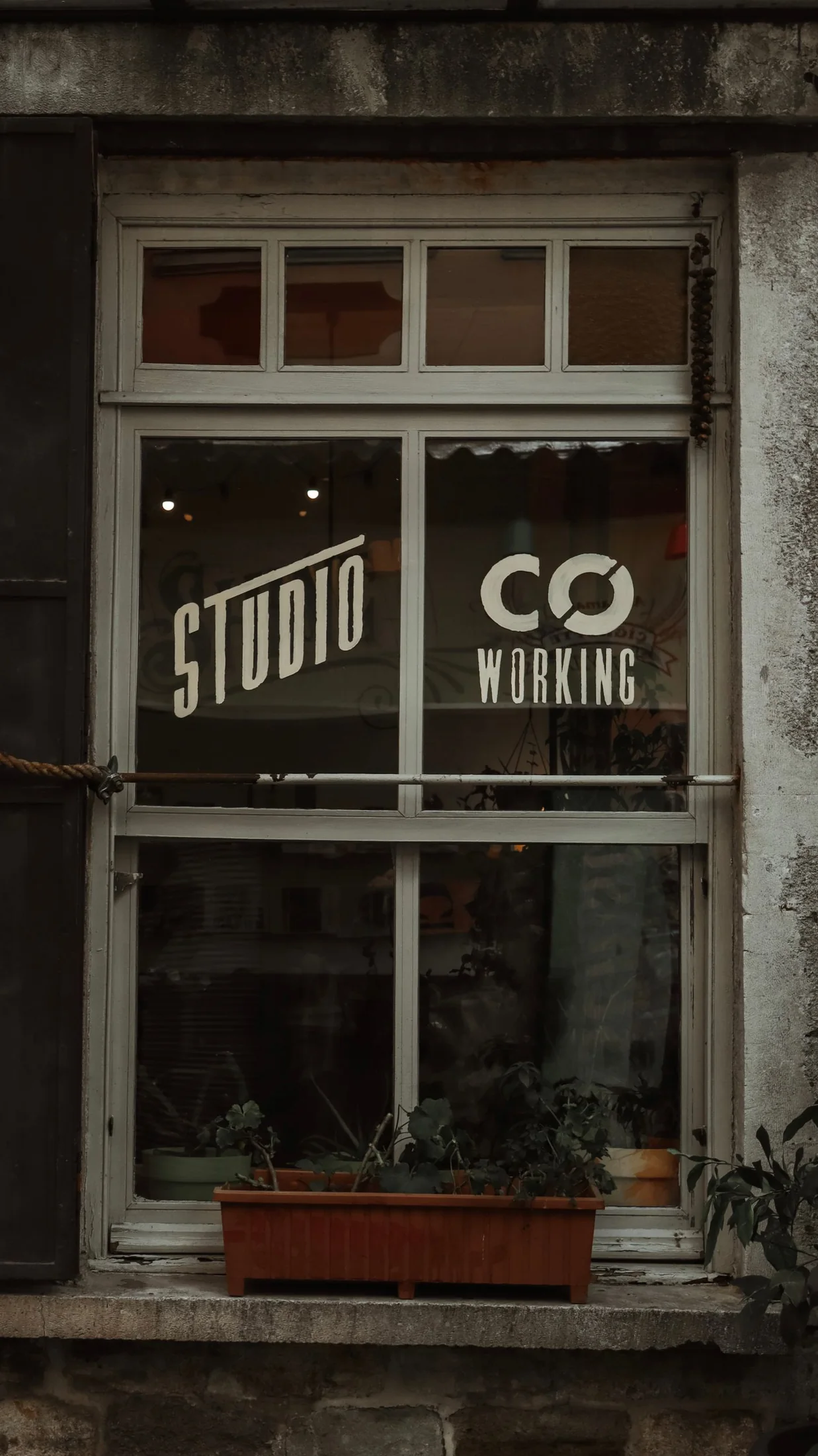 Dòng chữ Studio Coworking dán trên cửa kính, ảnh tham khảo Pexels.