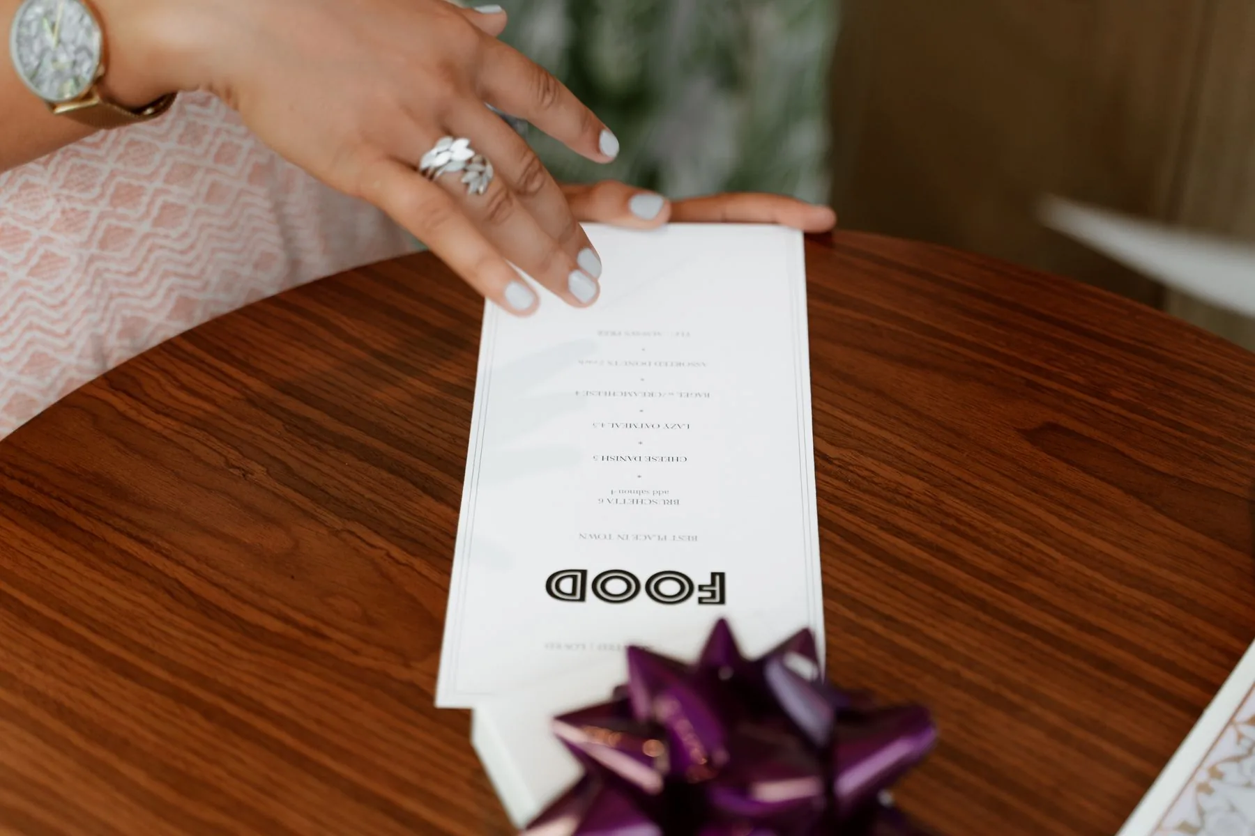 Thực đơn in cầm tay trên bàn gỗ — ảnh Pexels.